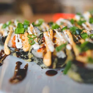 Carnival Roll - Tempura Shrimp deep fried roll with Hot Mess Mix, Cream Cheese &amp; Avocado topped with Jalapeno, Spicy Mayo, Lime Crema, etc.