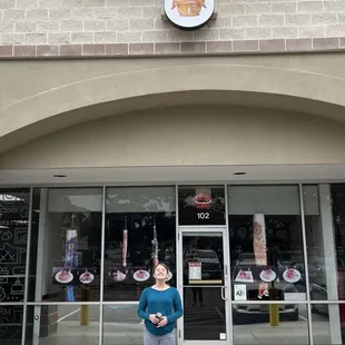 a woman standing in front of a sushiholic store
