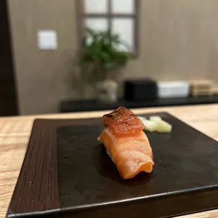 a piece of salmon on a black plate