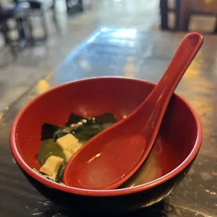 a red bowl with a spoon in it