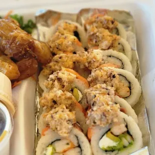a tray of sushi rolls with sauce