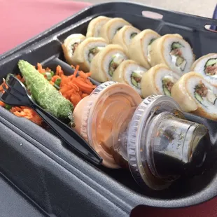 a tray of sushi and vegetables