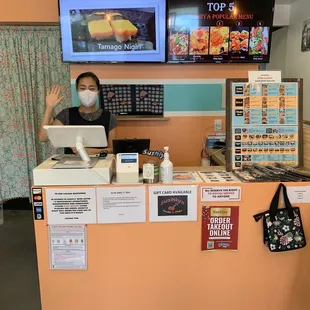 a woman wearing a face mask behind a counter