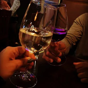 two people holding wine glasses