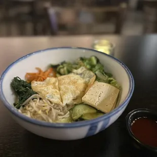 a bowl of noodles with tofu and vegetables