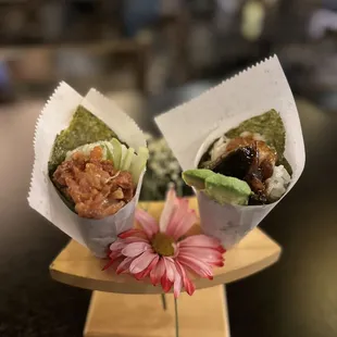 two pieces of sushiya on a plate with a flower