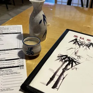 a picture of a vase and a menu on a table