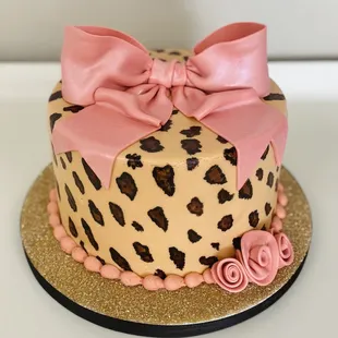 a leopard print cake with a pink bow