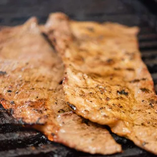 two pieces of meat on a grill