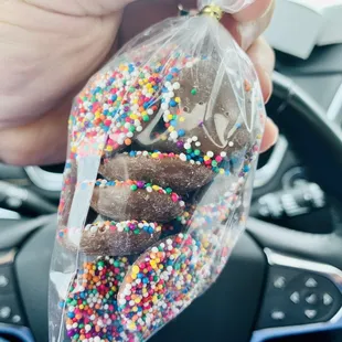 a person holding a bag of donuts