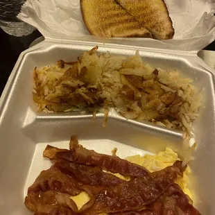 Scrambled eggs , hash browns, bacon and white toast