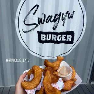 a person holding a plate of onion rings