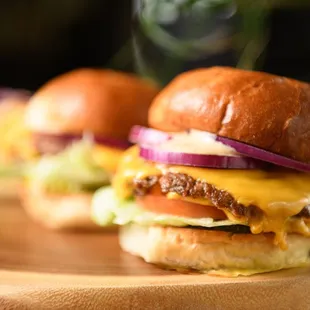 two burgers on a wooden plate