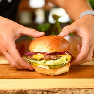 a person holding a hamburger