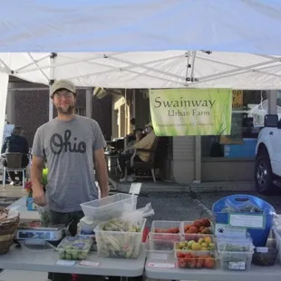 a man standing in front of a table of produce