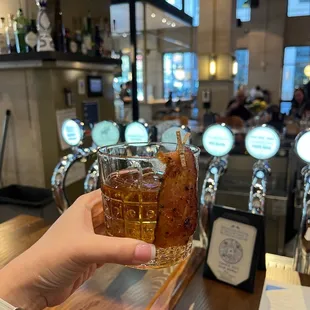 a person holding a glass of beer