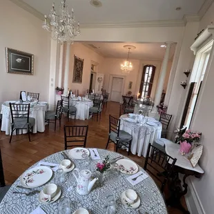 a dining room with tables, chairs, and a chandelier