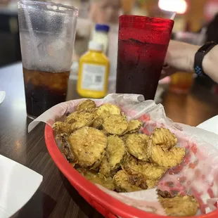 a basket of fried oysters and a glass of soda