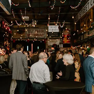a large crowd of people standing around a table