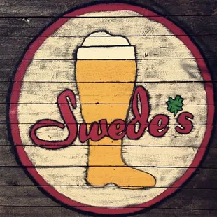 a wooden sign with a glass of beer