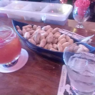 a bowl of peanuts and a drink