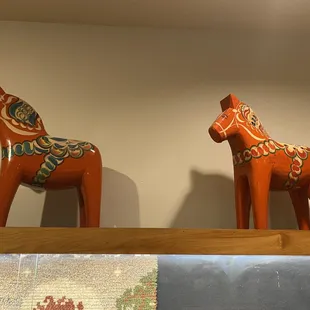 two wooden horses on a shelf