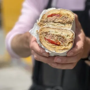 a person holding a sandwich