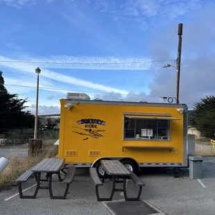 a yellow food truck parked in a parking lot