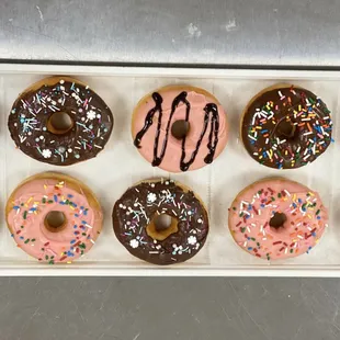 a tray of donuts with chocolate frosting and sprinkles