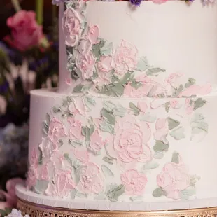 a white wedding cake with pink and blue flowers