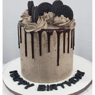 a cake with chocolate drips and cookies