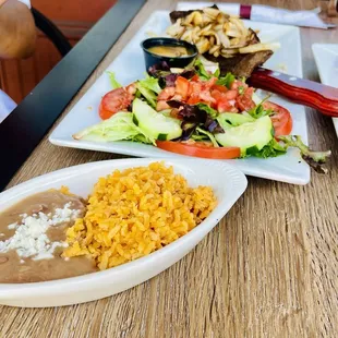 Skirt Steak with onions and mushrooms, salad, rice and refried beans.