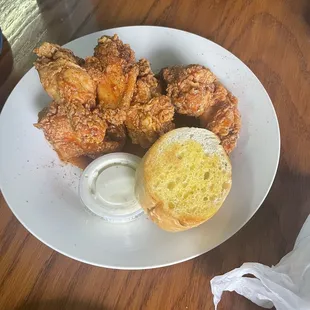 a plate of fried chicken and a biscuit