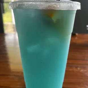 a blue drink in a plastic cup