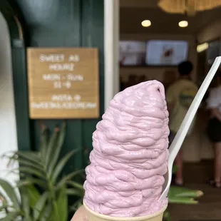 a hand holding a pink ice cream cone