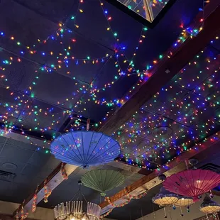 a ceiling decorated with lights and umbrellas