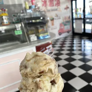 Single scoop of pecan praline on a sugar cone