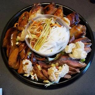 OG Platter with pork rinds, Lao sausage, steak, wings, papaya salad. Also includes sticky rice.