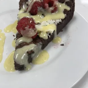 Flourless chocolate cake with white chocolate sauce and fresh raspberries