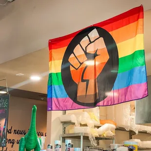 An inclusive rainbow flag with the raised fist symbol!