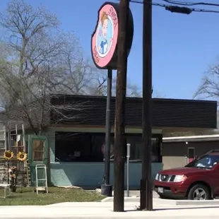 a red car parked in front of a restaurant
