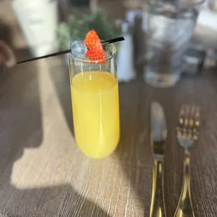a glass of orange juice with a straw