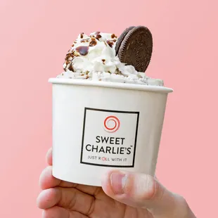 a hand holding a cup of ice cream