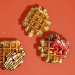 three waffles with strawberries and chocolate