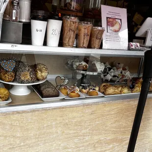 Display case featuring baked goods and hot drinks