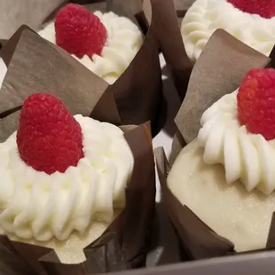 Delicious Vanilla Cupcakes with Raspberry Filling and Cream Cheese Icing Topped With Fresh Raspberries