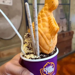 a person holding a cup of ice cream