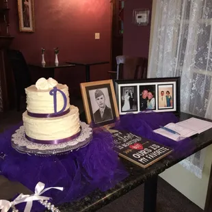 a table with a cake and pictures
