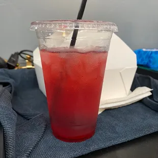 a red drink in a plastic cup with a straw