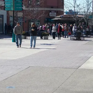 a crowd of people walking on a sidewalk